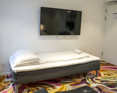 Enkeltværelse på A Hotels City med seng, hvidt sengetøj og fladskærms-tv.