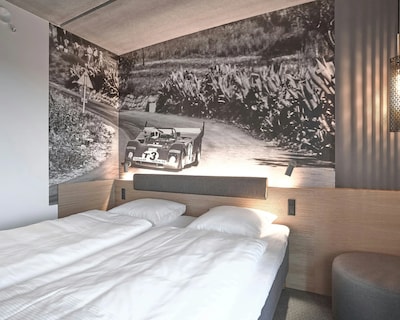 Senge med hvide lagner og et racerbil-vægmaleri på Four Points Flex by Sheraton Lyngby.