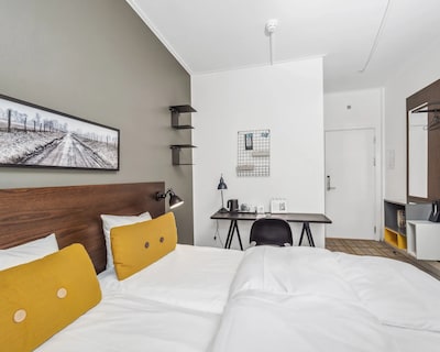 Hotelværelse på Ibsens Hotel med dobbeltseng og skrivebord.