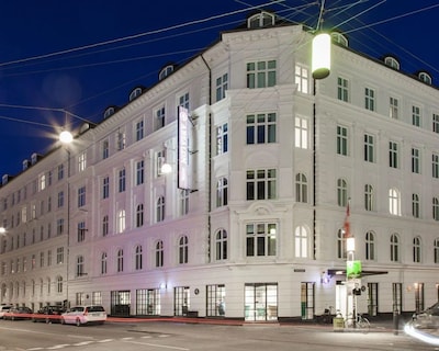 Absalon Hotel bygning i København om aftenen med gadebelysning.